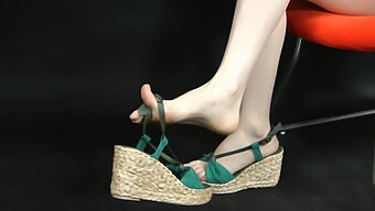 การซูมเท้าของนางแบบเอเชียที่จัดแสดงในรองเท้าแตะ Espadrille แบบลิ่ม